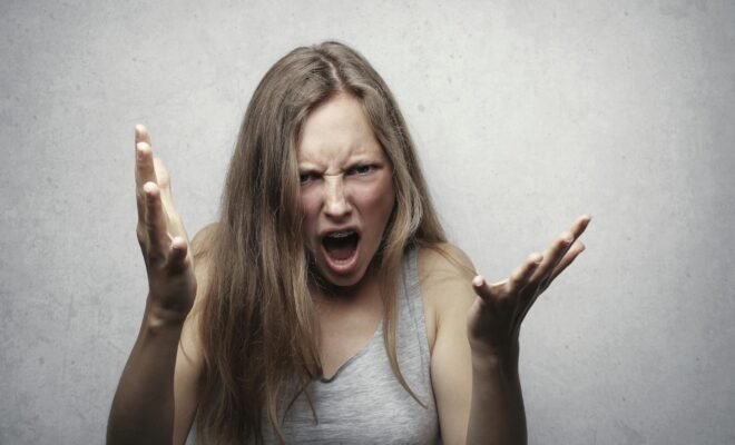 Woman screaming with hands inthe air