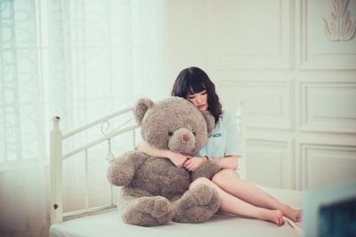 woman hugging teddy bear