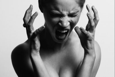 Woman screaming with her hands open near her face