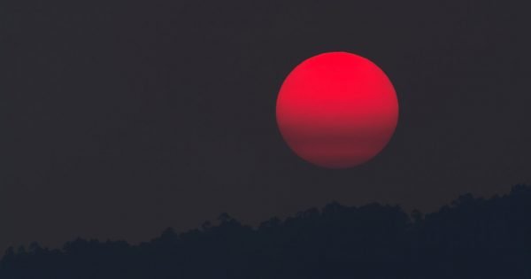 Blood red moon hanging in a black sky