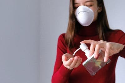 woman with face mask and hand sanitizer