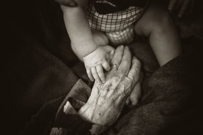 child holding hand of aging person