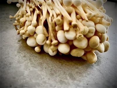 A pile of enoki mushrooms on a quartz countertop