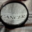 newspaper with the word cancer magnified