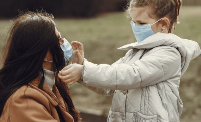 parent and child wearing masks outdoors
