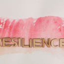 the word resilience in wooden letters on a water color paint background