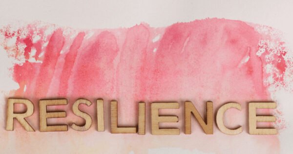 the word resilience in wooden letters on a water color paint background