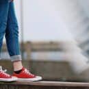 girl in jeans and red converse on a ledge