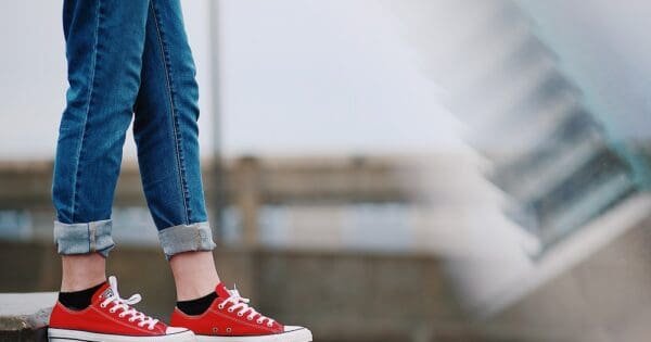 girl in jeans and red converse on a ledge