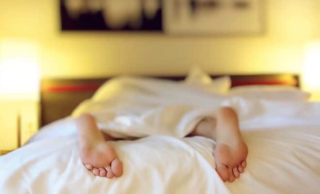 person resting in bed with only feet showing out of the covers