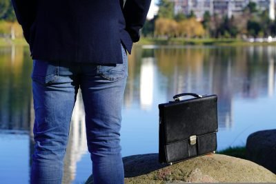 A man next to attaché case in the park