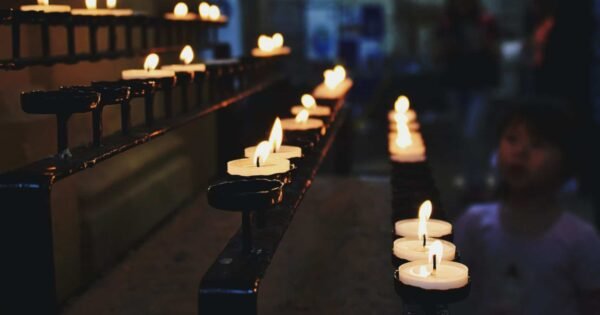 white candles lit in what appears to be a church