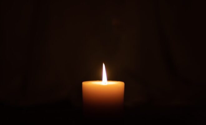 lit candle in a dark room