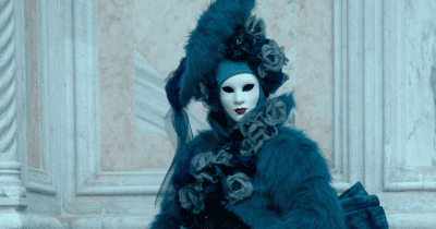 a woman in a white mask with red lips wearing a fancy black dress with roses and furs