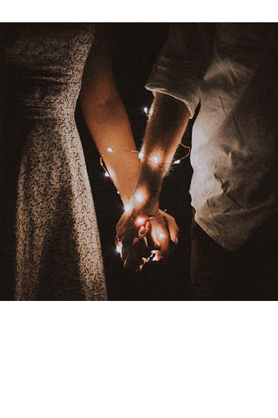 Image of a couple holding hands with lights on the hands