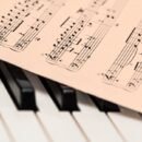 piano keys with a page of sheet music sitting on top