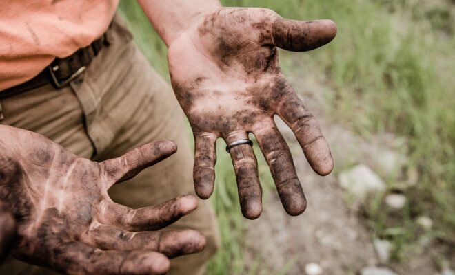 A man's hand covered in dirt