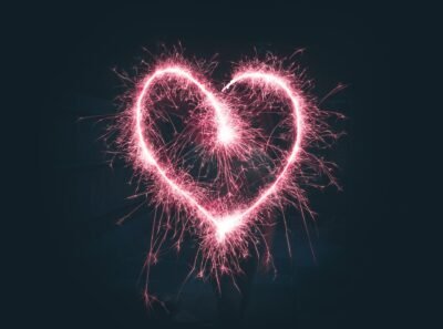 A red heart, drawn by a sparkler, briefly crackles against the dark