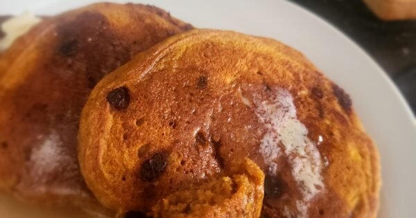 sourdough pumpkin chocolate chip pancakes on a plate covered in syrup