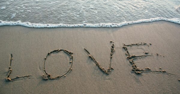 Word LOVE written in Sand