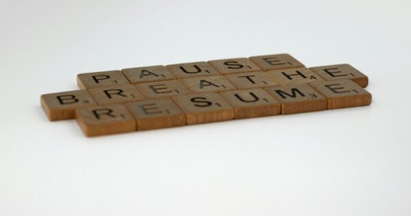 wooden tiles that say pause, breathe, resume against a white background