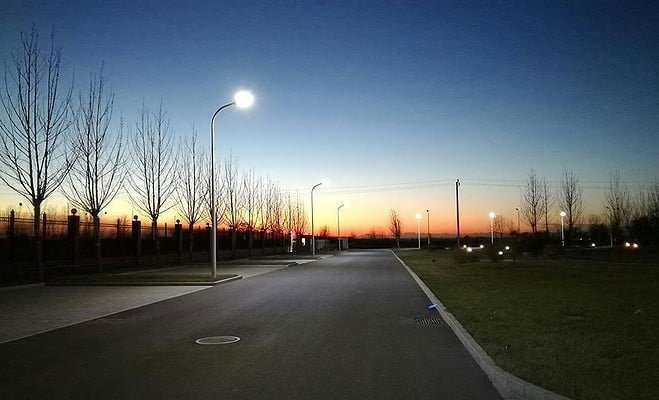 A highway lined with street lamps at dusk