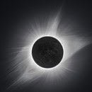 An image of a total solar eclipse with the corona flaring brightly
