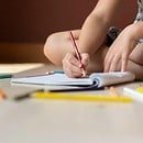 A child drawing in a sketchbook