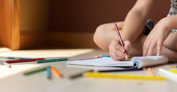 A child drawing in a sketchbook