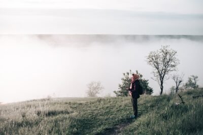 A woman gazing upon the fog in forest
