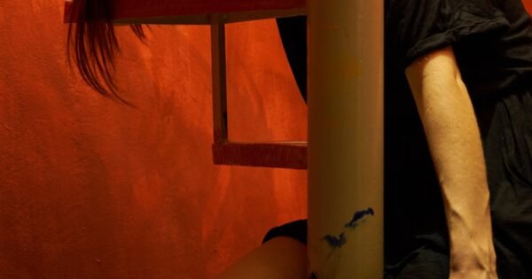 Woman in black dress sleeping on stairs.