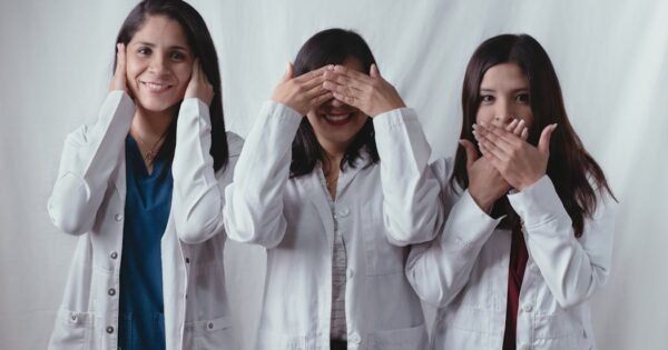 Nurse roles in healthcare. Three healthcare workers in a row. One covering ears, one covering eyes, and one covering mouth.