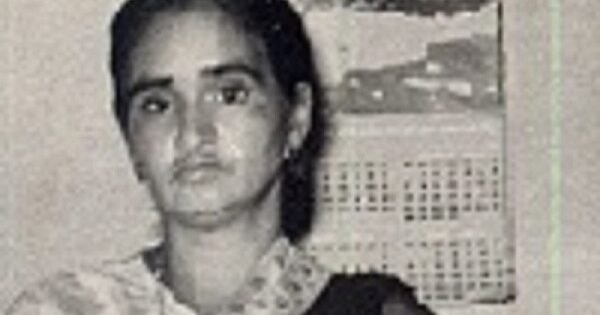 A black and white photograph of an Indian woman in a traditional sari dress