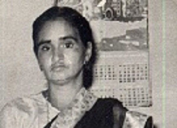 A black and white photograph of an Indian woman in a traditional sari dress