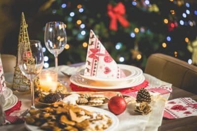 Christmas table set with wine glass, plates, and cookies