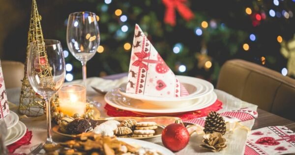 Christmas table set with wine glass, plates, and cookies