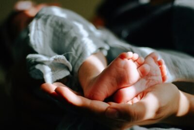 A baby's feet cradled in the palm of a hand