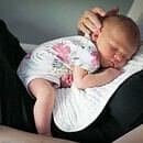 a woman holding a sleeping baby