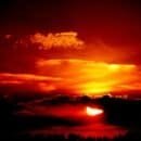 The sun descending below the horizon