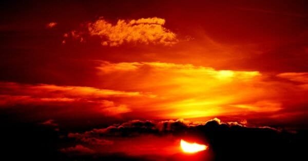 The sun descending below the horizon