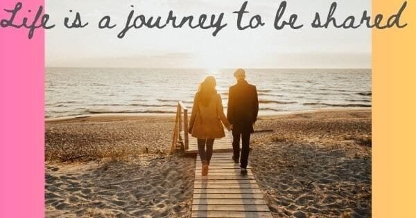 couple walking toward the beach holding hands