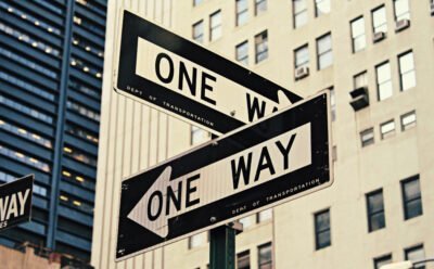 Two one way street signs pointing in opposite directions.