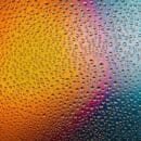 Rain on glass with a gradient of light behind.