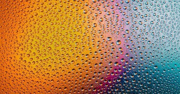 Rain on glass with a gradient of light behind.