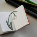 Mini unlined notebook with a flower illustration.