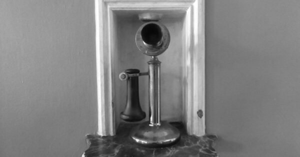 Black and white photo of a candlestick telephone