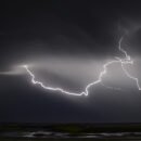 A thunderstorm over the ocean at night