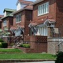 A residential neighborhood with brick houses and uniform lawns.