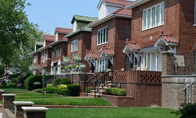 A residential neighborhood with brick houses and uniform lawns.