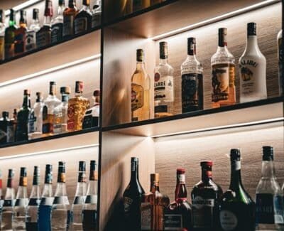 Bottles of liquor sit in perfect rows along backlit shelves